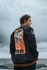 Black Nylon Astroboy Bomber jacket in black and orange. Has a zipper with an orange tag on the left sleeve with Astroboy written on one side and Bibisama on the other. Has Astroboy x Bibisama patch on the right sleeve.