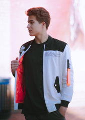 White cotton Astroboy Bomber jacket in white and orange. Has a zipper with an orange tag on the left sleeve with Astroboy written on one side and Bibisama on the other. Has Astroboy x Bibisama patch on the right sleeve. On the left chest, Astroboy is written on top with information on manufacturer and designer.