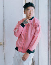 Pink Nylon bomber jacket, influenced by the Chinese Zodiac Pig with zipper on the left sleeve and the pig birth year on the right sleeve.  Has the pig characteristic on the left chest with black and white design inside the jacket. Back of the Jacket is an embroidery of the pig with inside pocket on the left side.